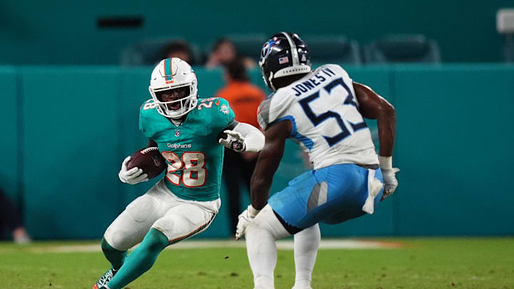 Sep 30, 2024; Miami Gardens, Florida, USA; Miami Dolphins running back De'Von Achane (28) runs the ball against Tennessee Titans linebacker Ernest Jones IV (53) during the second half at Hard Rock Stadium. Mandatory Credit: Jasen Vinlove-Imagn Images
