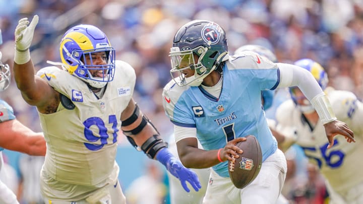 Tennessee Titans quarterback Cam Ward evades Los Angeles Rams defensive end Kobie Turner.