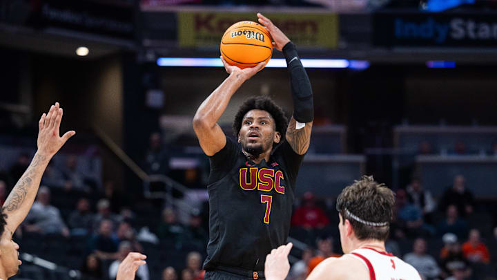Mar 12, 2025; Indianapolis, IN, USA; USC Trojans guard Chibuzo Agbo (7) shoots the ball while Rutgers Scarlet Knights center Zach Martini (99) defends in the first half at Gainbridge Fieldhouse. Mandatory Credit: Trevor Ruszkowski-Imagn Images