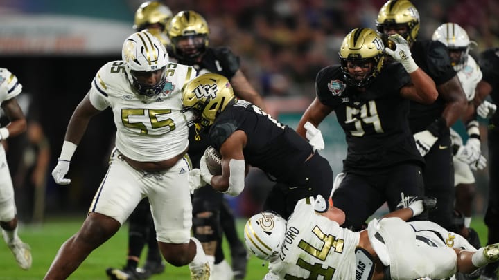 Dec 22, 2023; Tampa, FL, USA; Georgia Tech Yellow Jackets linebacker Kyle Efford (44) and Georgia Tech Yellow Jackets defensive lineman Horace Lockett (55) bring down UCF Knights running back RJ Harvey (7) during the first half of the Gasparilla Bowl at Raymond James Stadium. Mandatory Credit: Jasen Vinlove-USA TODAY Sports