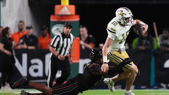 Oct 7, 2023; Miami Gardens, Florida, USA; Miami Hurricanes defensive back Daryl Porter Jr. (2) tackles Georgia Tech Yellow Jackets quarterback Haynes King (10) in the first half at Hard Rock Stadium. Mandatory Credit: Jasen Vinlove-Imagn Images