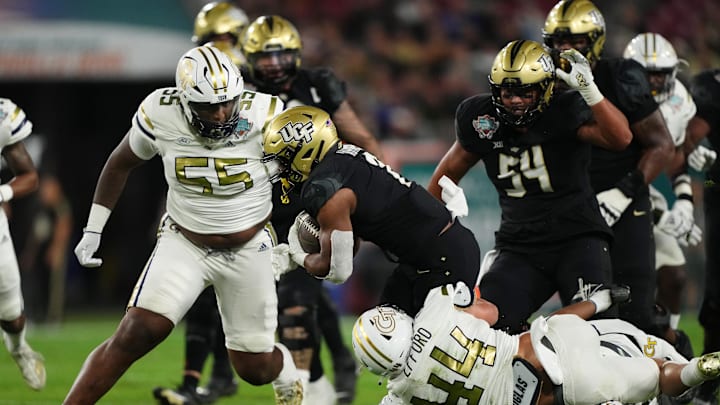 Dec 22, 2023; Tampa, FL, USA; Georgia Tech Yellow Jackets linebacker Kyle Efford (44) and Georgia Tech Yellow Jackets defensive lineman Horace Lockett (55) bring down UCF Knights running back RJ Harvey (7) during the first half of the Gasparilla Bowl at Raymond James Stadium. Mandatory Credit: Jasen Vinlove-Imagn Images Dec 22, 2023; Tampa, FL, USA; Georgia Tech Yellow Jackets linebacker Kyle Efford (44) and Georgia Tech Yellow Jackets defensive lineman Horace Lockett (55) bring down UCF Knights running back RJ Harvey (7) during the first half of the Gasparilla Bowl at Raymond James Stadium. Mandatory Credit: Jasen Vinlove-Imagn Images
