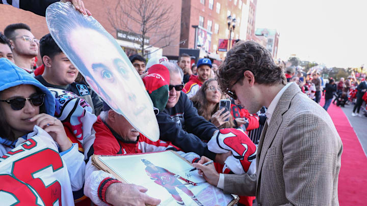 Oct 16, 2025; Newark, New Jersey, USA; New Jersey Devils center Jack Hughes (86) signs an autograph for a fan before the start of the Devils home opener against the Florida Panthers at Prudential Center. Mandatory Credit: Ed Mulholland-Imagn Images
