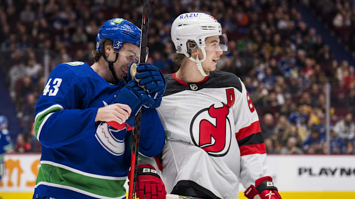 Mar 15, 2022; Vancouver, British Columbia, CAN; Vancouver Canucks defenseman Quinn Hughes (43) shares laugh with his brother New Jersey Devils forward Jack Hughes (86) in the second period at Rogers Arena. Mandatory Credit: Bob Frid-Imagn Images