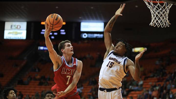 LMU Lions guard Jan Vide (7) scores despite a leaping block attempt by UTEP Miners forward Jamal West Jr. (15) during a game at the Don Haskins Center, Nov. 11, 2025, in El Paso, Texas.