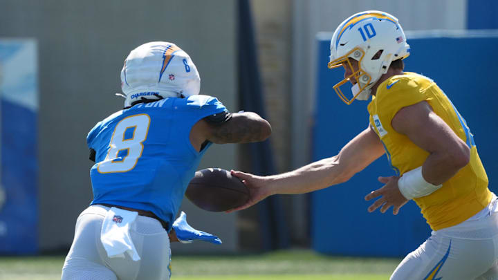 Los Angeles Chargers quarterback Justin Herbert (10) hands the ball off to running back Omarion Hampton (8) during training camp