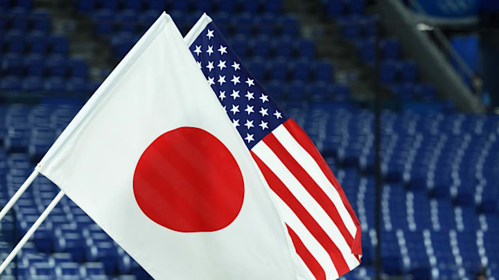 Yokohama, Japan; The flags of Japan and the United States of America are raised during the playing of the national anthems before the gold medal game in the Tokyo 2020 Olympic Summer Games at Yokohama Baseball Stadium.