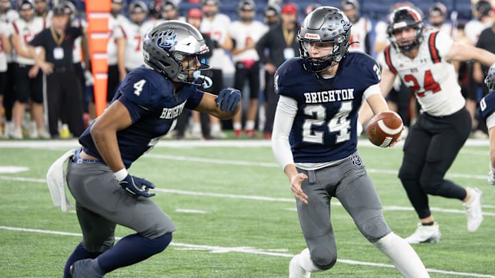 Brighton's Ethan Bialaszewski (24) hands off to Justin Medina during the New York State Class A final against Section I's Rye last season.