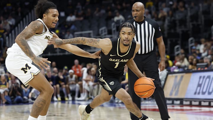 Oct 20, 2024; Detroit, MI, USA;  Oakland Golden Grizzlies guard Jaylen Jones (1) dribbles while defended by Michigan Wolverines guard Phat Phat Brooks (8) in the second half at Little Caesars Arena. Mandatory Credit: Rick Osentoski-Imagn Images