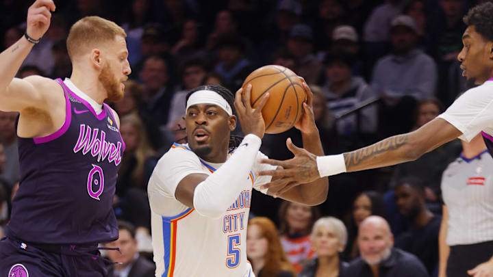 Dec 19, 2025; Minneapolis, Minnesota, USA; Oklahoma City Thunder forward Luguentz Dort (5) works between Minnesota Timberwolves guard Donte DiVincenzo (0) and forward Jaden McDaniels (3) in the first quarter at Target Center. Mandatory Credit: Bruce Kluckhohn-Imagn Images