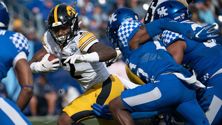 Iowa running back Kaleb Johnson (2) rushes past Kentucky defenders during the first quarter of the TransPerfect Music City Bowl, Saturday, Dec. 31, 2022, at Nissan Stadium in Nashville, Tenn.
