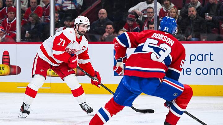 Jan 10, 2026; Montreal, Quebec, CAN; Detroit Red Wings center Dylan Larkin (71) plays the puck against Montreal Canadiens defenseman Noah Dobson (53) during the second period at Bell Centre. Mandatory Credit: David Kirouac-Imagn Images