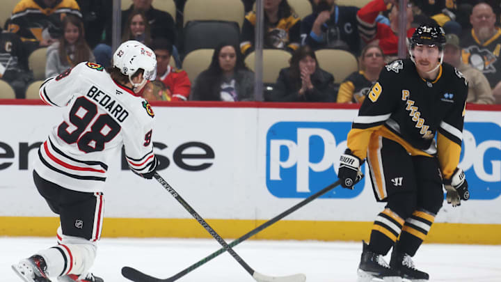 Apr 8, 2025; Pittsburgh, Pennsylvania, USA;  Chicago Blackhawks center Connor Bedard (98) shoots against Pittsburgh Penguins center Connor Dewar (19) during the third period at PPG Paints Arena. Mandatory Credit: Charles LeClaire-Imagn Images