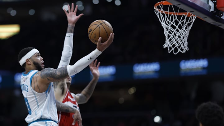 Mar 8, 2024; Washington, District of Columbia, USA; Charlotte Hornets forward Miles Bridges (0) shoots the ball as Washington Wizards forward Kyle Kuzma (33) defends in the second half at Capital One Arena. Mandatory Credit: Geoff Burke-Imagn Images
