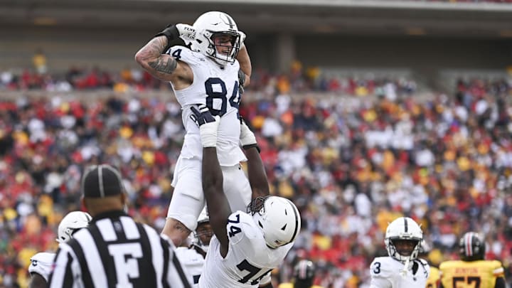 Penn State Nittany Lions offensive lineman Olumuyiwa Fashanu lifts Theo Johnson