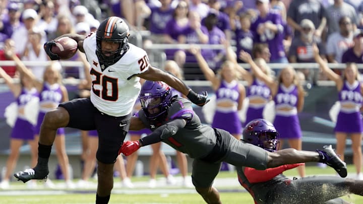Oct 15, 2022; Fort Worth, Texas, USA; Oklahoma State Cowboys running back Dominic Richardson (20) runs past  TCU Horned Frogs safety Abraham Camara (14) during the first half at Amon G. Carter Stadium. Mandatory Credit: Raymond Carlin III-Imagn Images