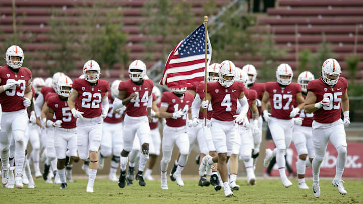 Nov 14, 2020; Stanford, California, USA; Against a background of empty seats and Pittosporum trees, the Stanford Cardinal team takes the field before an NCAA college football game against the Colorado Buffaloes at Stanford Stadium. 