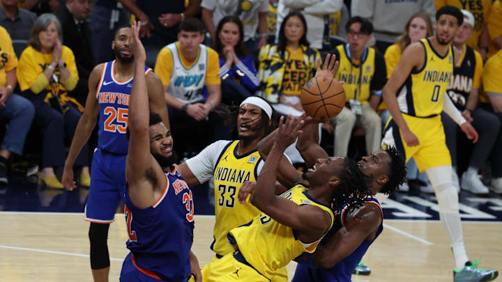 May 27, 2025; Indianapolis, Indiana, USA; Indiana Pacers forward Aaron Nesmith (23) drives to the hoop past New York Knicks center Karl-Anthony Towns (32) during the fourth quarter of game four of the eastern conference finals for the 2025 NBA Playoffs at Gainbridge Fieldhouse. Mandatory Credit: Trevor Ruszkowski-Imagn Images