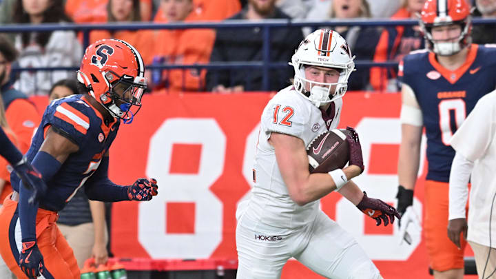 Nov 2, 2024; Syracuse, New York, USA; Virginia Tech Hokies wide receiver Stephen Gosnell (12) runs past Syracuse Orange defensive back Marcellus Barnes Jr. (7) after making a catch in the first quarter at JMA Wireless Dome. Mandatory Credit: Mark Konezny-Imagn Images