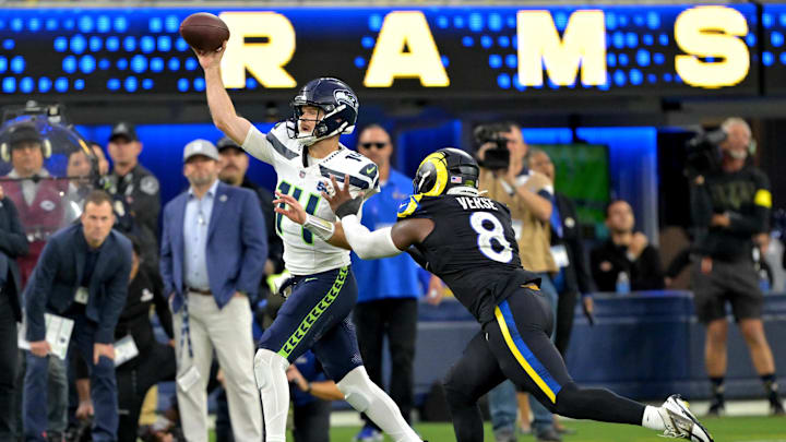 Nov 16, 2025; Inglewood, California, USA;  Seattle Seahawks quarterback Sam Darnold (14) is pressured by Los Angeles Rams linebacker Jared Verse (8) at SoFi Stadium. Mandatory Credit: Jayne Kamin-Oncea-Imagn Images