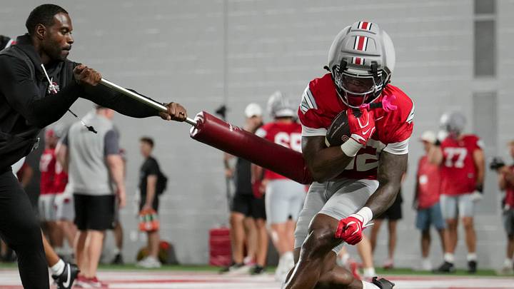 Ohio State Buckeyes running back Isaiah West (32) works on a ball security drill with coach Cortez Hankton during football training camp inside the Woody Hayes Athletic Center in Columbus on Aug. 7, 2026.