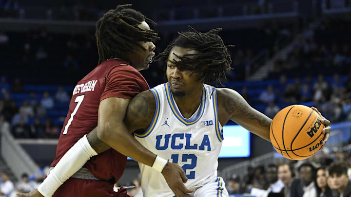 Nov 4, 2024; Los Angeles, California, USA; UCLA Bruins guard Sebastian Mack (12) drives to the basket defended by Rider Broncs forward Ife West-Ingram (7) during the first half at Pauley Pavilion presented by Wescom. Mandatory Credit: Robert Hanashiro-Imagn Images