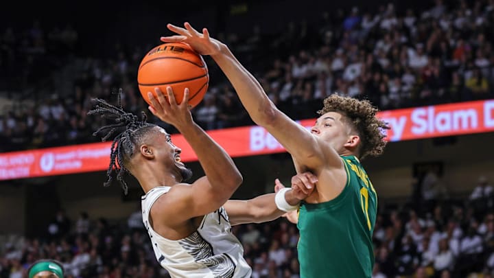Feb 28, 2026; Orlando, Florida, USA; Baylor Bears guard Dan Skillings Jr. (0) blocks a shot by UCF Knights guard Themus Fulks (1) during the first half at Addition Financial Arena. Mandatory Credit: Mike Watters-Imagn Images