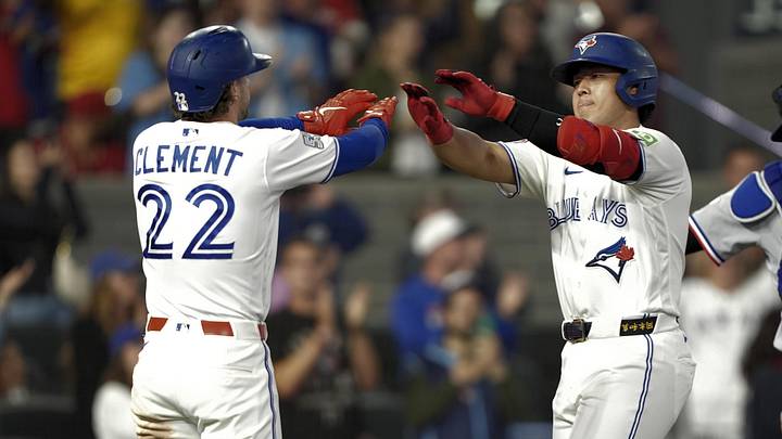 Toronto Blue Jays shortstop Ernie Clement (22) congratulates third baseman Kazuma Okamoto (7) on his two-run home run.