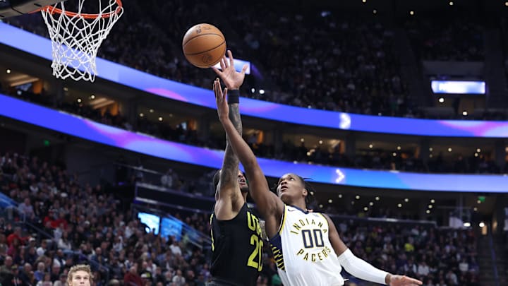 Jan 15, 2024; Salt Lake City, Utah, USA; Indiana Pacers guard Bennedict Mathurin (00) lays the ball up past Utah Jazz forward John Collins (20) during the second quarter at Delta Center. Mandatory Credit: Rob Gray-Imagn Images