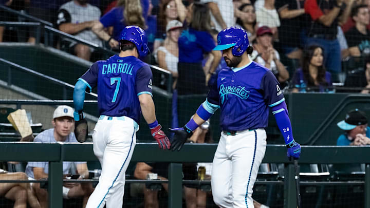 Jun 13, 2025; Phoenix, Arizona, USA; Arizona Diamondbacks outfielder Corbin Carroll (7) celebrates with teammate Eugenio Suarez after scoring in the third inning against the San Diego Padres at Chase Field. Mandatory Credit: Mark J. Rebilas-Imagn Images
