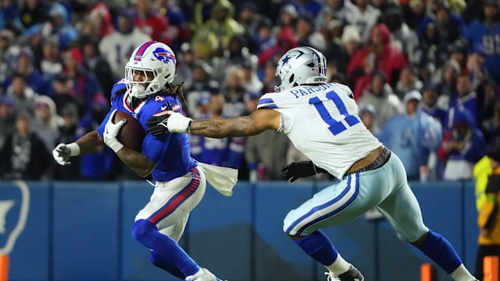 Dec 17, 2023; Orchard Park, New York, USA; Buffalo Bills running back James Cook (4) runs the ball pressured by Dallas Cowboys linebacker Micah Parsons (11) in the second half at Highmark Stadium. Mandatory Credit: Gregory Fisher-Imagn Images