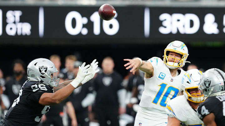 Jan 5, 2025; Paradise, Nevada, USA; Los Angeles Chargers quarterback Justin Herbert (10) makes a pass attempt under pressure from Las Vegas Raiders defensive tackle John Jenkins (95) during the first quarter at Allegiant Stadium. Mandatory Credit: Stephen R. Sylvanie-Imagn Images