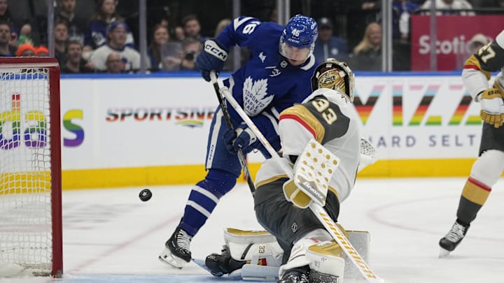 Nov 20, 2024; Toronto, Ontario, CAN; Toronto Maple Leafs forward Alex Steeves (46) tries to deflect a puck past Vegas Golden Knights goaltender Adin Hill (33) during the third period at Scotiabank Arena. Mandatory Credit: John E. Sokolowski-Imagn Images