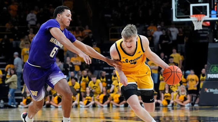 Iowa Hawkeyes guard Josh Dix (4) drives toward the basket as Washington Huskies guard Tyree Ihenacho (6) defends Saturday, Feb. 22, 2025 at Carver-Hawkeye Arenain Iowa City, Iowa.