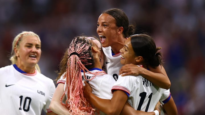 Sophia Smith, Mallory Swanson, and Trinity Rodman celebrate a goal against Germany during the Paris 2024 Olympic Summer Games.