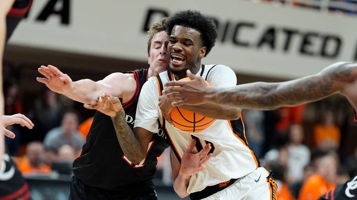 Oklahoma State guard Jaylen Curry (0) dribbles beside Davidson guard Sam Brown (11) during a first-round basketball game in the NIT between Oklahoma State and Davidson.