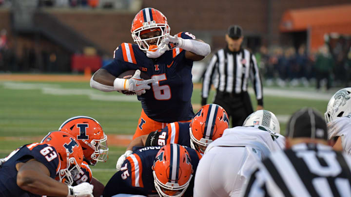 Nov 16, 2024; Champaign, Illinois, USA; Illinois Fighting Illini running back Josh McCray (6) leaps over the pile for a touchdown against the Michigan State Spartans during the second half at Memorial Stadium. Mandatory Credit: Ron Johnson-Imagn Images