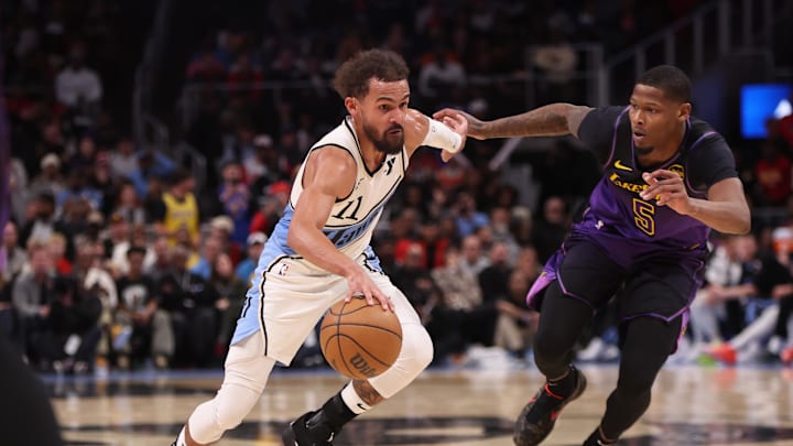 Dec 6, 2024; Atlanta, Georgia, USA; Atlanta Hawks guard Trae Young (11) drives past Los Angeles Lakers forward Cam Reddish (5) in overtime at State Farm Arena. Mandatory Credit: Brett Davis-Imagn Images