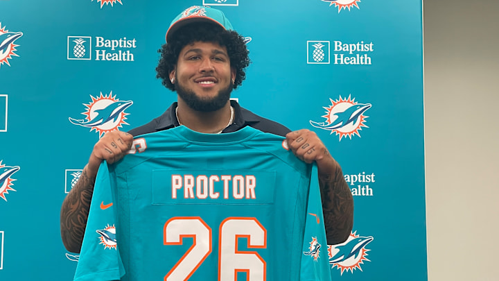 Miami Dolphins first-round pick Kadyn Proctor shows off his jersey at his introductory press conference
