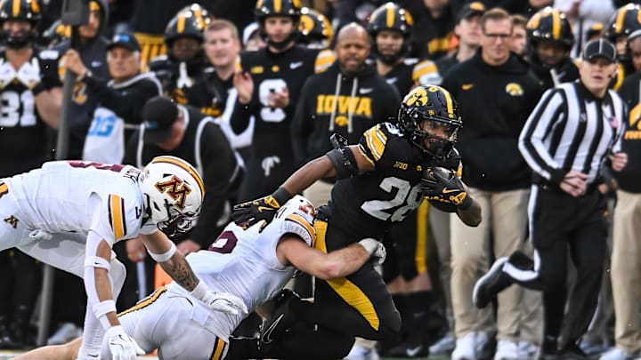Oct 25, 2025; Iowa City, Iowa, USA; Iowa Hawkeyes running back Kamari Moulton (28) is tackled by Minnesota Golden Gophers linebacker Maverick Baranowski (6) and defensive back Koi Perich (3) during the fourth quarter at Kinnick Stadium. Mandatory Credit: Jeffrey Becker-Imagn Images