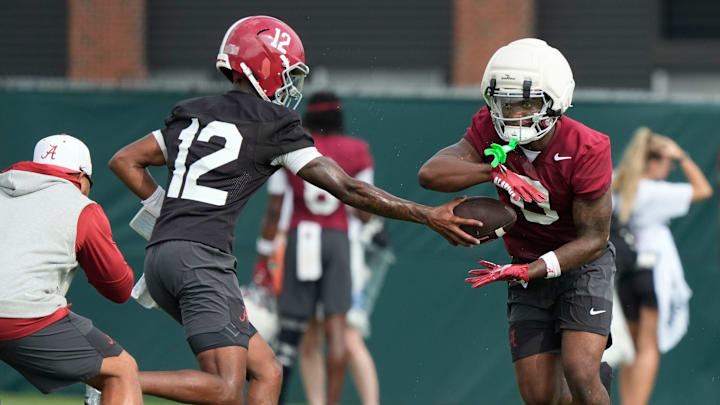 July 30, 2025; Tuscaloosa, AL, USA; Quarterback Keelon Russell hands off to running back AK Dear during the first practice session of the preseason for the Alabama Crimson Tide.