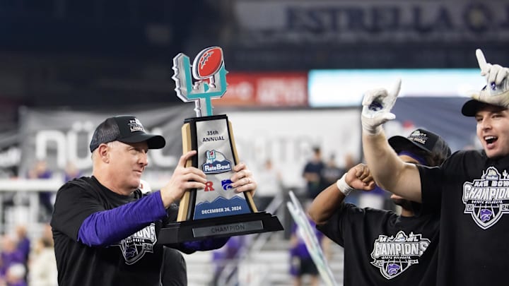 Dec 26, 2024; Phoenix, AZ, USA; Kansas State Wildcats head coach Chris Klieman celebrates with the trophy after defeating the Rutgers Scarlet Knights during the Rate Bowl at Chase Field. Mandatory Credit: Mark J. Rebilas-Imagn Images Dec 26, 2024; Phoenix, AZ, USA; Kansas State Wildcats head coach Chris Klieman celebrates with the trophy after defeating the Rutgers Scarlet Knights during the Rate Bowl at Chase Field. Mandatory Credit: Mark J. Rebilas-Imagn Images