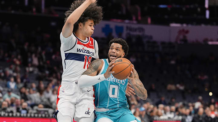 Feb 3, 2025; Charlotte, North Carolina, USA;  Charlotte Hornets forward Miles Bridges (0) goes to the basket against Washington Wizards forward Kyshawn George (18) during the first half at Spectrum Center. Mandatory Credit: Jim Dedmon-Imagn Images