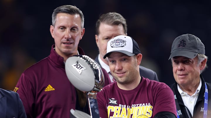 Dec 7, 2024; Arlington, TX, USA; Arizona State Sun Devils head coach Kenny Dillingham looks at the trophy after winning the Big 12 Championship game against the Iowa State Cyclones at AT&T Stadium. Mandatory Credit: Tim Heitman-Imagn Images