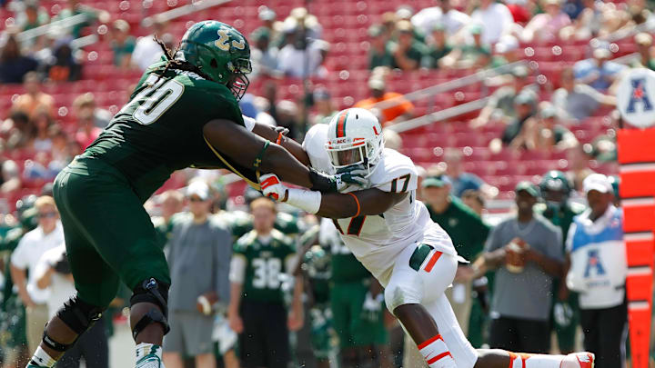 Sep 28, 2013; Tampa, FL, USA;Miami Hurricanes linebacker Tyriq McCord (17) rushes past South Florida Bulls offensive linesman Quinterrius Eatmon (70)  during the second half at Raymond James Stadium. Miami Hurricanes defeated the South Florida Bulls 49-21. Mandatory Credit: Kim Klement-Imagn Images