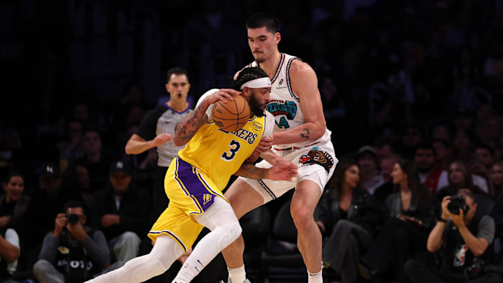 Nov 13, 2024; Los Angeles, California, USA;  Los Angeles Lakers forward Anthony Davis (3) dribbles the ball against Memphis Grizzlies center Zach Edey (14) during the third quarter at Crypto.com Arena. Mandatory Credit: Kiyoshi Mio-Imagn Images