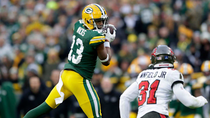 Green Bay Packers wide receiver Dontayvion Wicks (13) catches a pass in front of the defense of Tampa Bay Buccaneers safety Antoine Winfield Jr. (31) during their football game on Sunday, December 17, 2023, at Lambeau Field in Green Bay Wis. Tampa Bay defeated Green Bay 34-20.