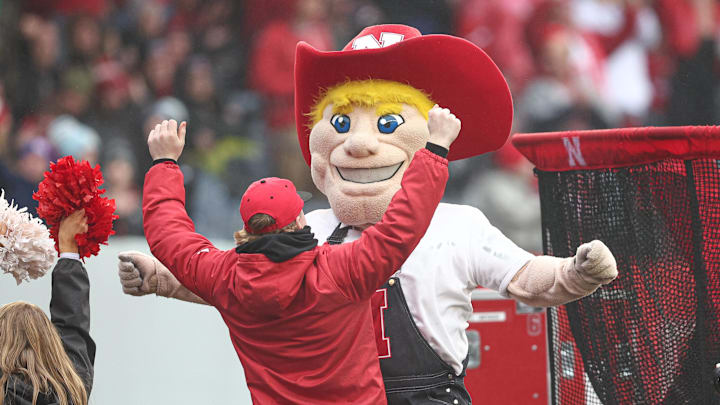 The Nebraska mascot celebrates with a fan during the 2024 Pinstripe Bowl.