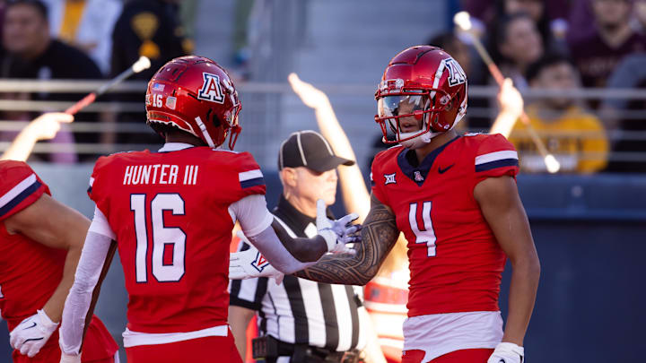Nov 30, 2024; Tucson, Arizona, USA; Arizona Wildcats wide receiver Tetairoa McMillan (4) celebrates a touchdown with teammate Chris Hunter (16) against the Arizona State Sun Devils in the second half during the Territorial Cup at Arizona Stadium. Mandatory Credit: Mark J. Rebilas-Imagn Images
