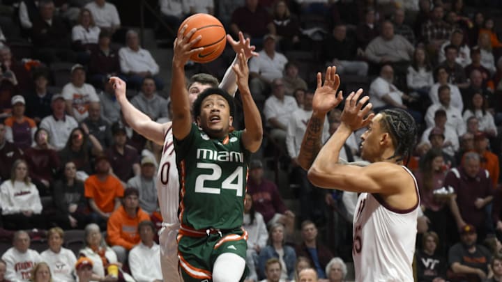 Feb 21, 2023; Blacksburg, Virginia, USA; Miami (Fl) Hurricanes guard Nijel Pack (24) drives past Virginia Tech Hokies guard Hunter Cattoor (0) and Virginia Tech Hokies center Lynn Kidd (15) in the first half at Cassell Coliseum. Mandatory Credit: Lee Luther Jr.-USA TODAY Sports